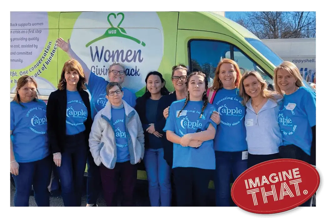 volunteers in front of a women giving back van